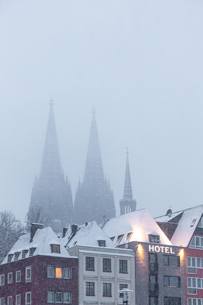 Häuser der Altstadt, im Hintergrund die Domspitzen im Nebel