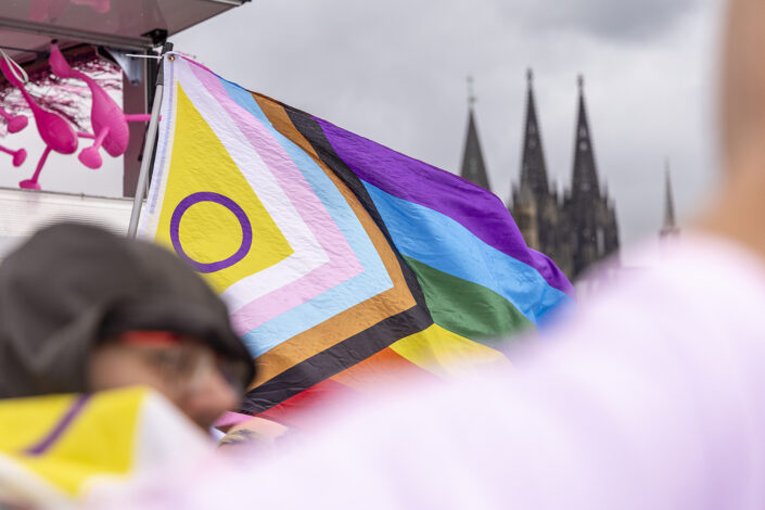 LGBTQ+ Pride Flagge auf der Deutzer Brücke mit den Kölner Dom im Hintergrund