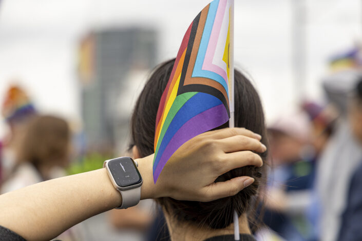 LGBTQ+ Pride Flagge im Haar einer Teilnehmerin