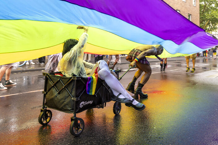 Teilnehmende des CSD 2025 unter einer großen Regenbogenflagge