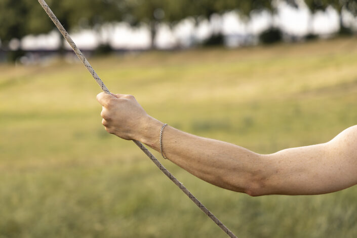 Eine Hand hält ein Seil beim Flying Pole Training