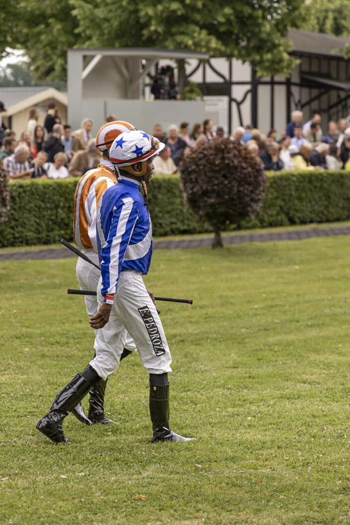 Jockeys auf dem Führring; in blauem Dress: Eduardo "Eddie" Pedroza, im orangen Dress: Leon Wolff