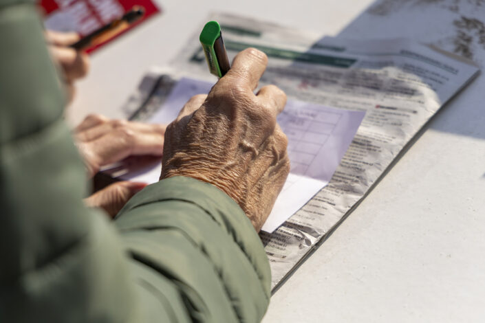 Hand, die einen Wettschein auf der Galopprennbahn Köln-Weidenpesch ausfüllt