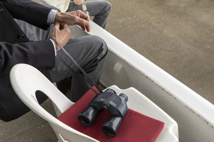 Zuschauer mit Fernglas auf der Tribüne der Galopprennbahn Köln-Weidenpesch