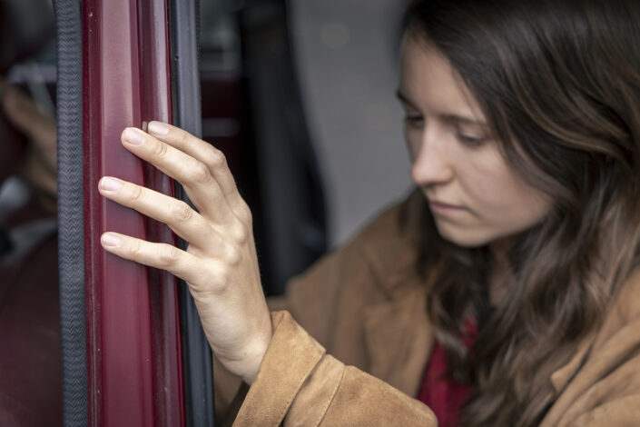 Entspanntes Porträt einer Frau in einem Auto, aufgenommen in Köln.